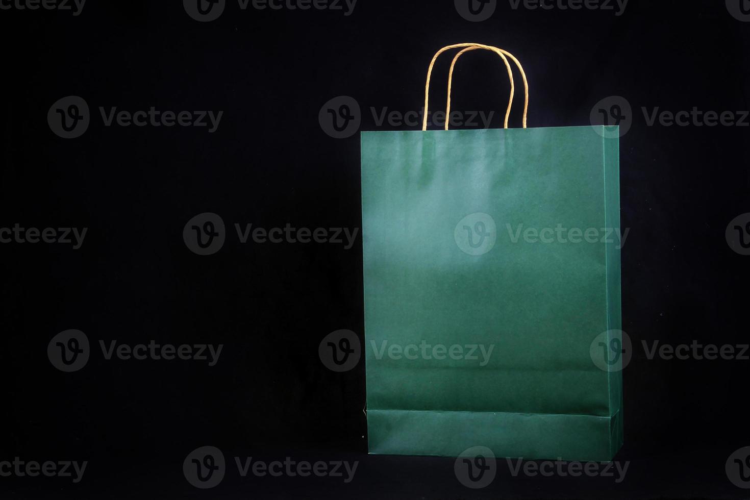Plain green paper bag packaging on a black background with copy space photo