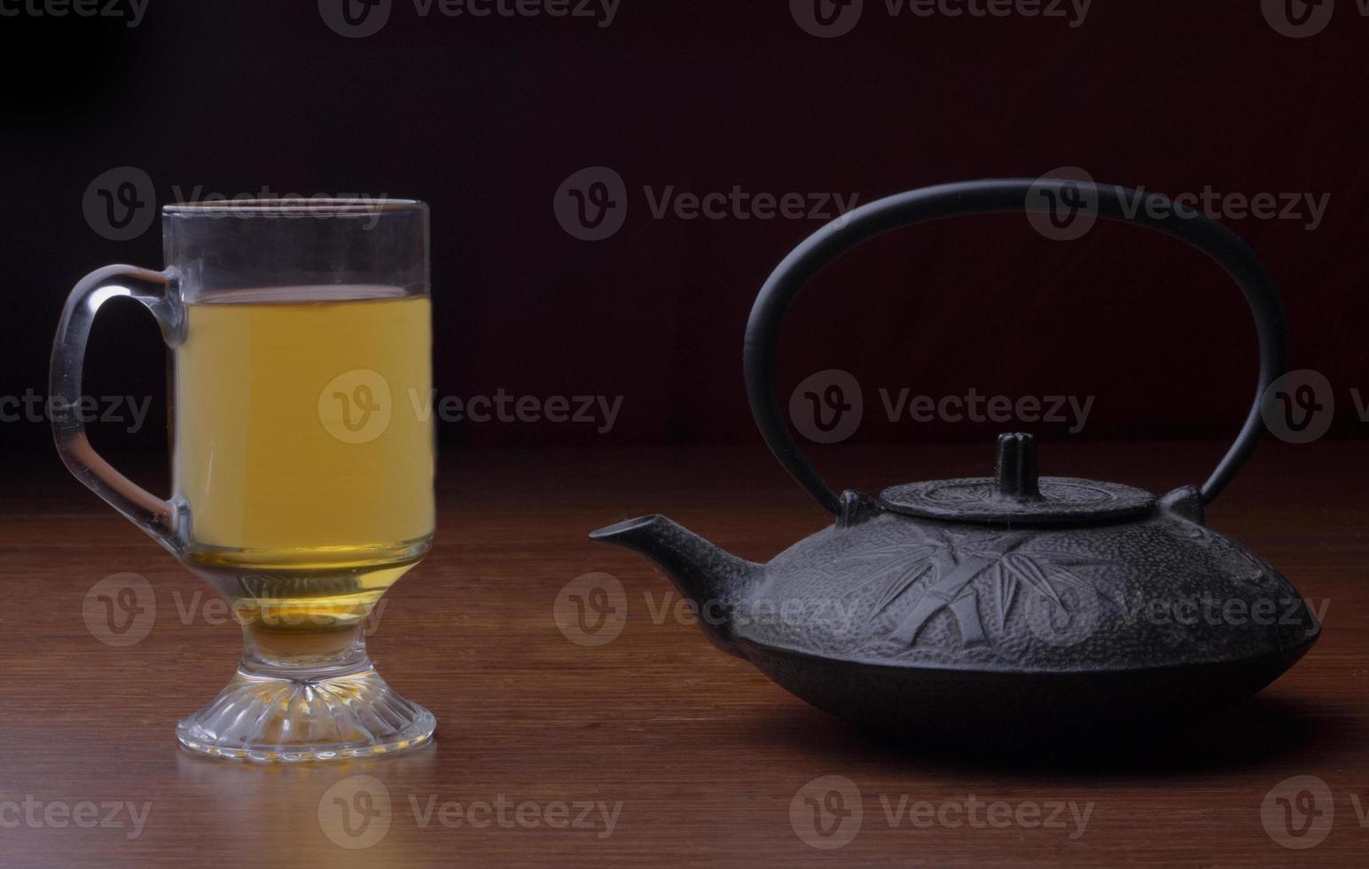 cast iron tea pot with a cup of tea photo