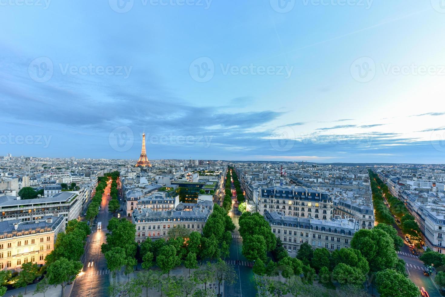 View of the the Eiffel Tower and the Paris city skyline into the distance at dusk. photo