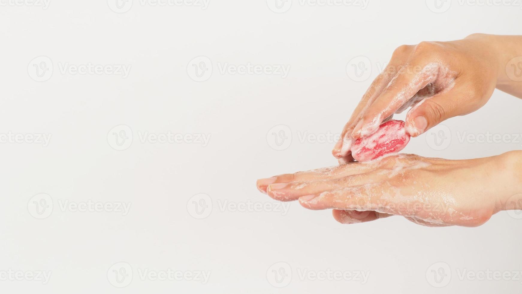 Hands washing with foaming and pink soap on white background. Studio shot photo