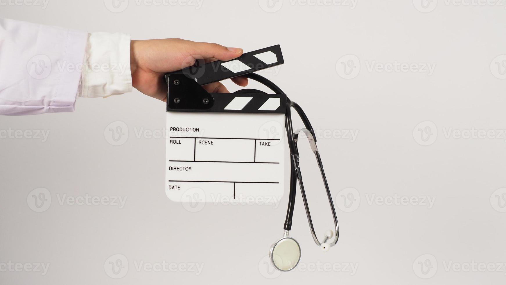 Clapper board and stethoscope in doctor's hand on white background. Studio shooting. photo