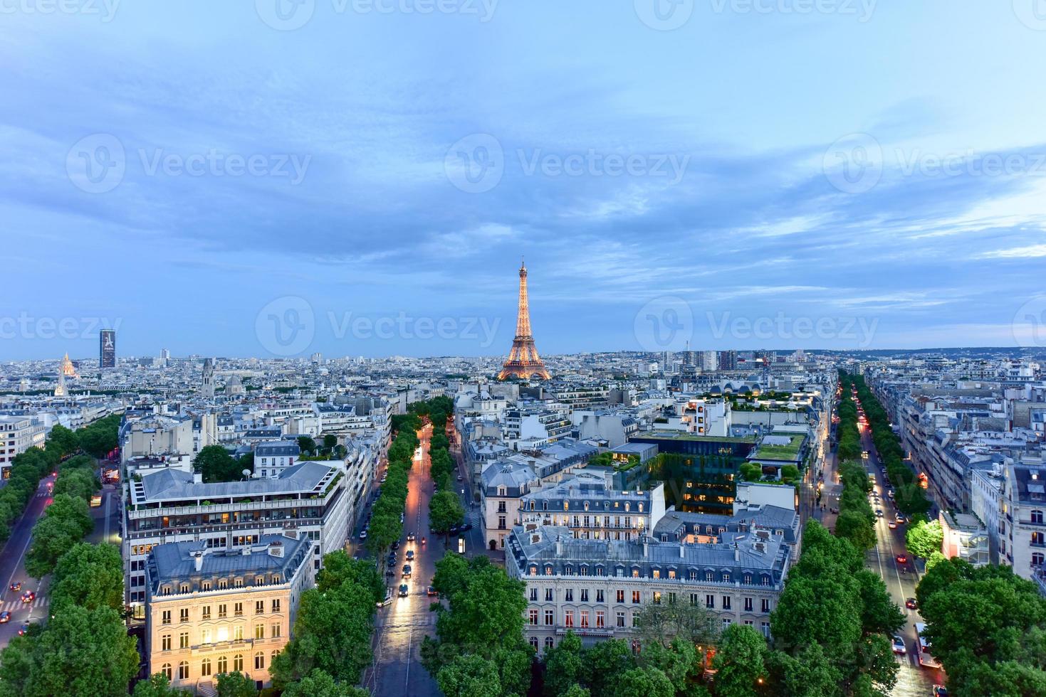 View of the the Eiffel Tower and the Paris city skyline into the distance at dusk. photo