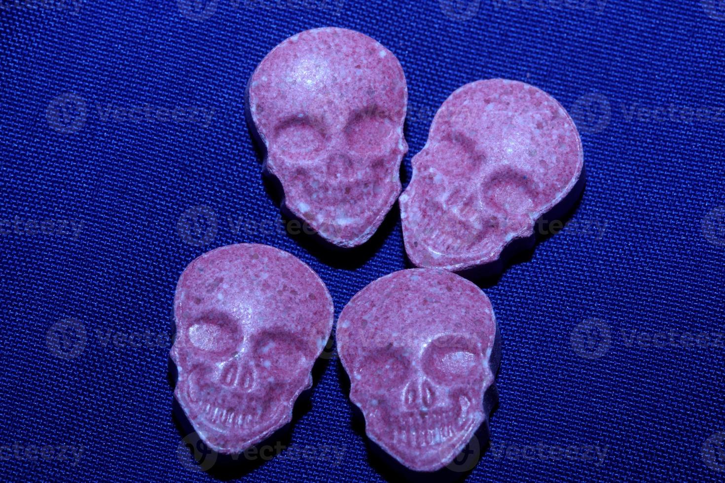 Pink skull ecstasy pill close up background high quality print purple army dope narcotics substance high dose psychedelic way of life photo