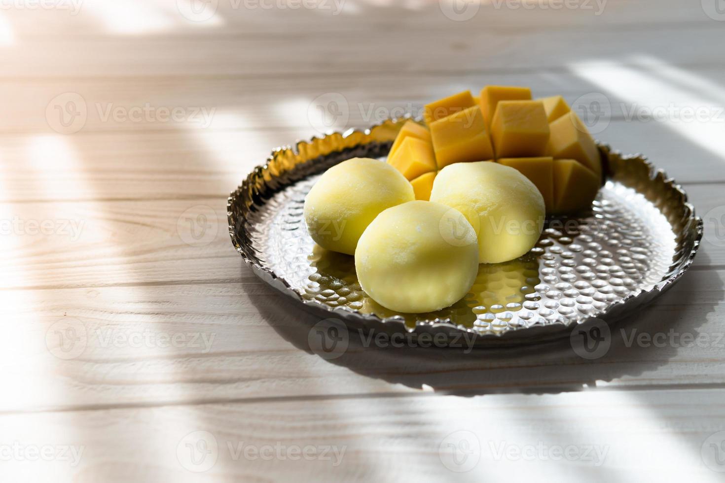 Tasty dessert Mochi with mango fruit on wooden background photo
