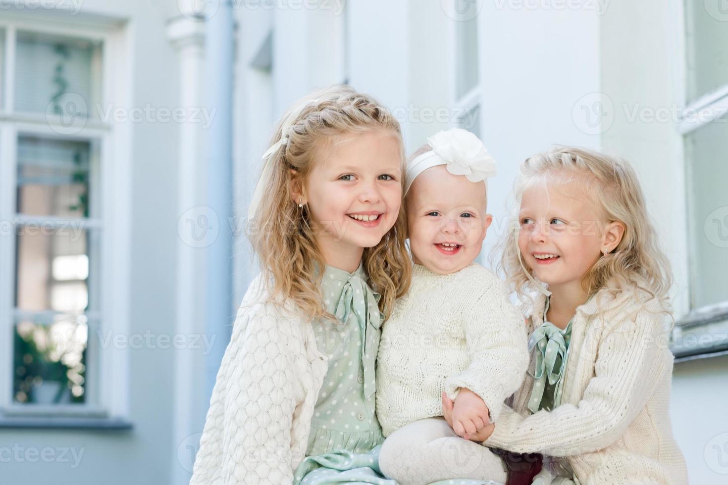 3 niñas de pelo claro se abrazan. amor de hermanas foto