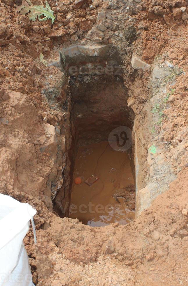 Freshly dug grave pit on the side of the road inside the residence for installation of gas pipes, a close-up. photo