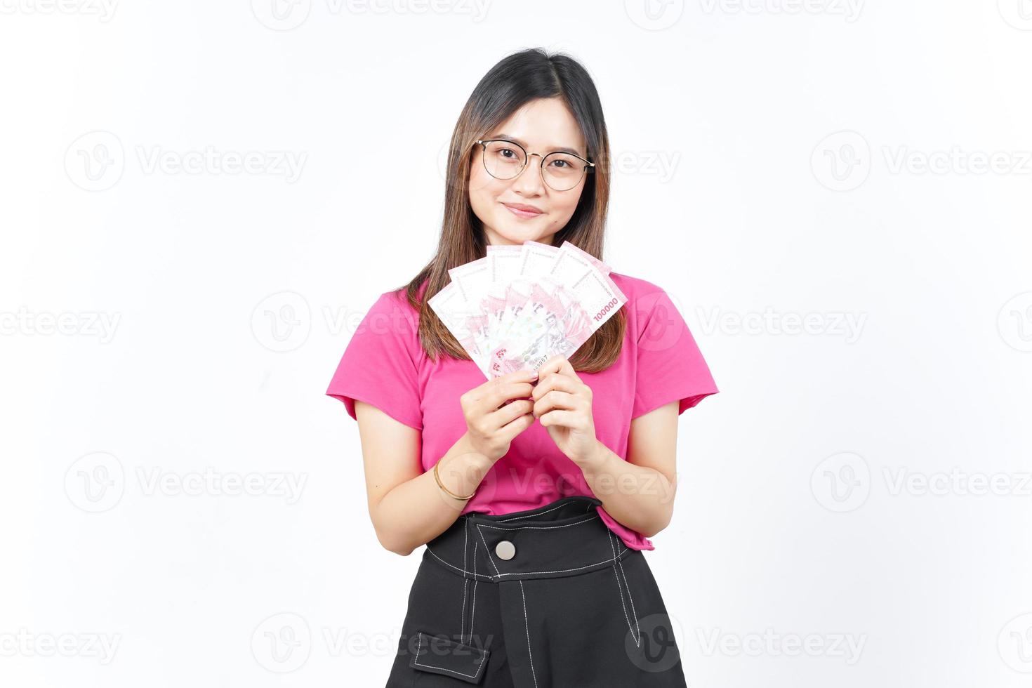 sosteniendo un nuevo billete de 100.000 rupias indonesias de una hermosa mujer asiática aislada de fondo blanco foto