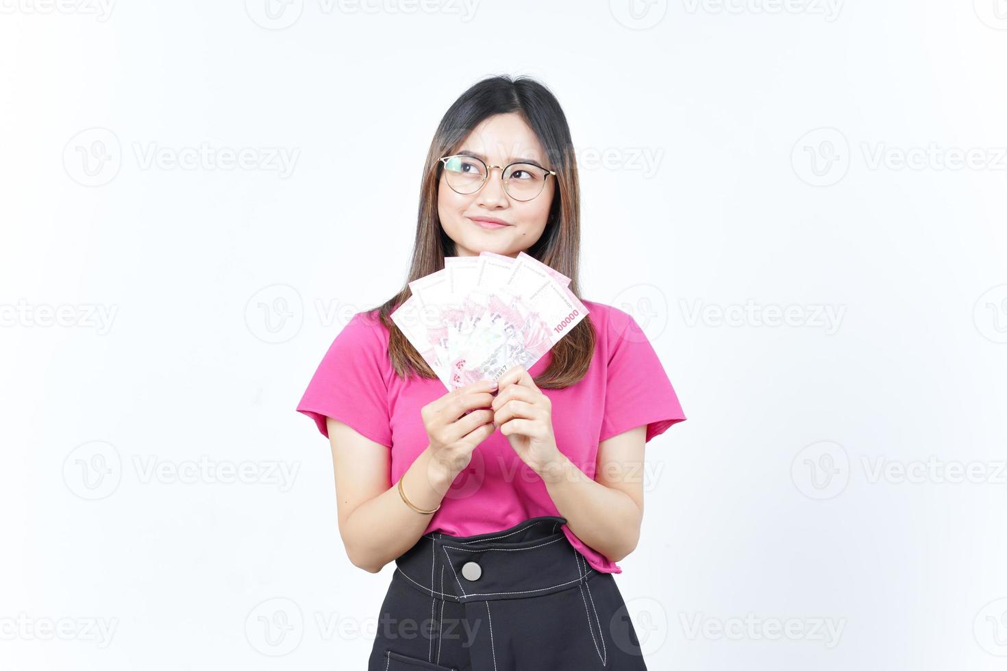 sosteniendo un nuevo billete de 100.000 rupias indonesias de una hermosa mujer asiática aislada de fondo blanco foto