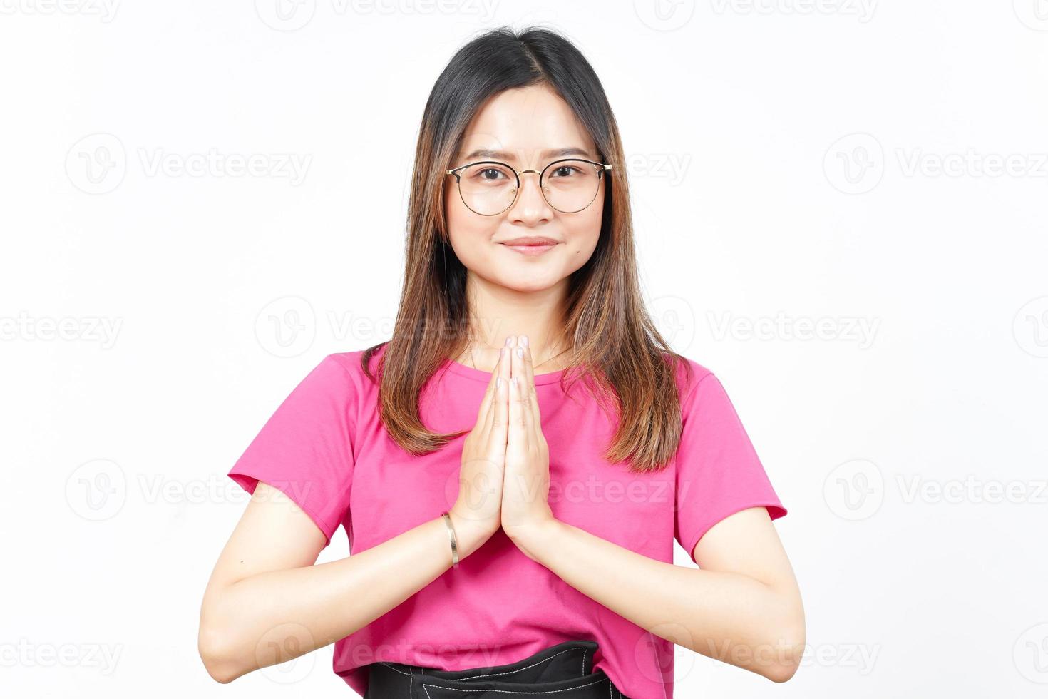 sonriendo y mirando a la cámara con el gesto namaste de una hermosa mujer asiática aislada en blanco foto