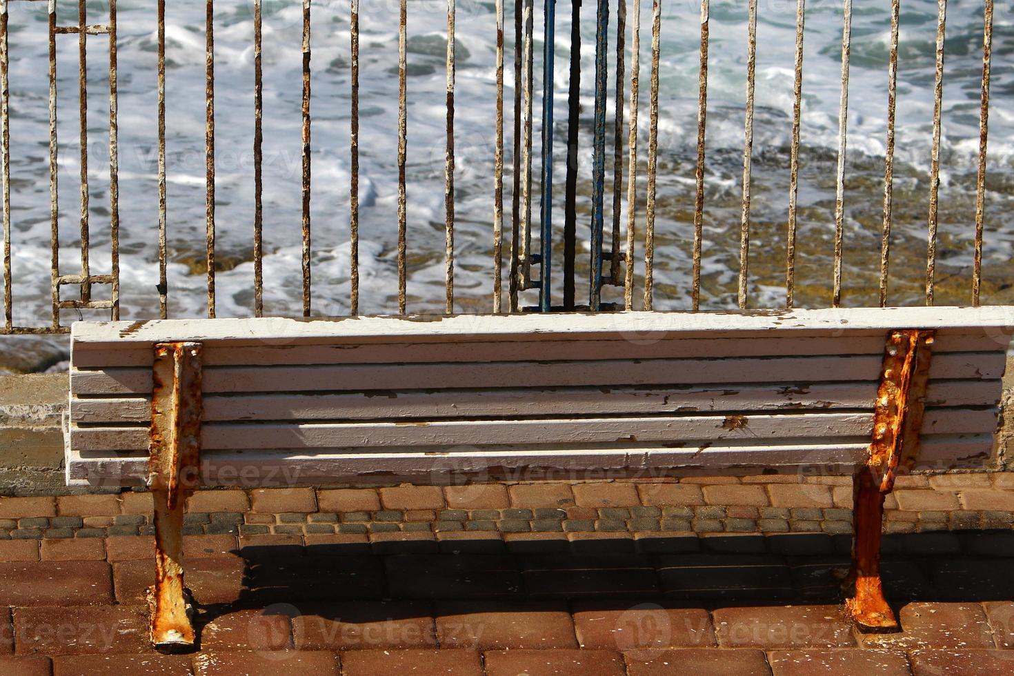 Bench for rest in the city park on the seashore. photo