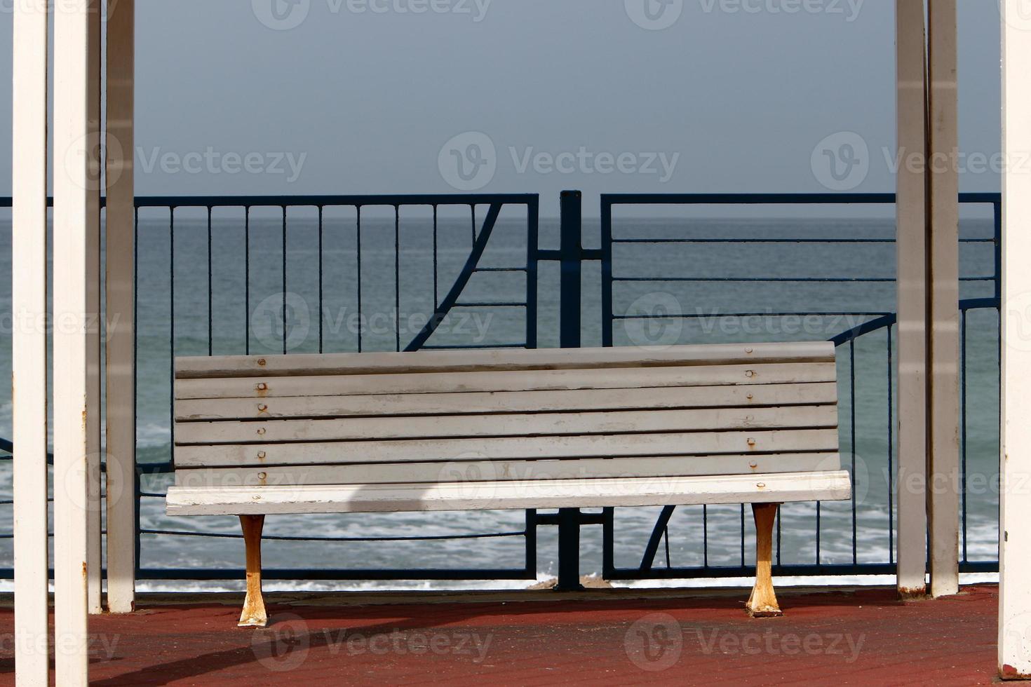 Bench for rest in the city park on the seashore. photo