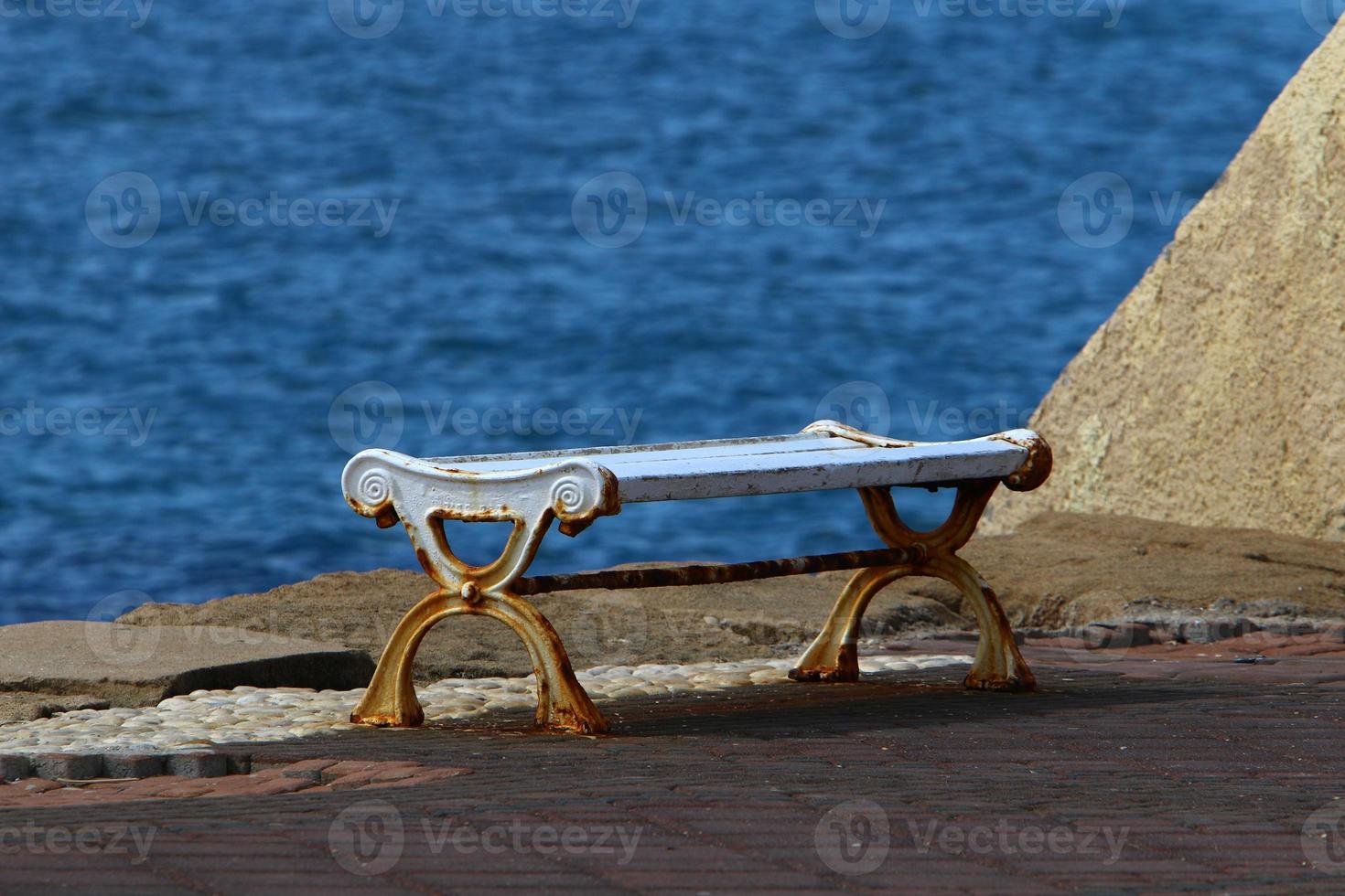 Bench for rest in the city park on the seashore. photo