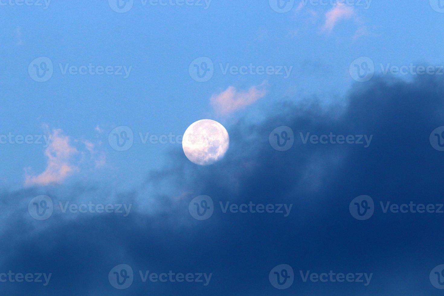 Moon and clouds in the sky over the sea photo