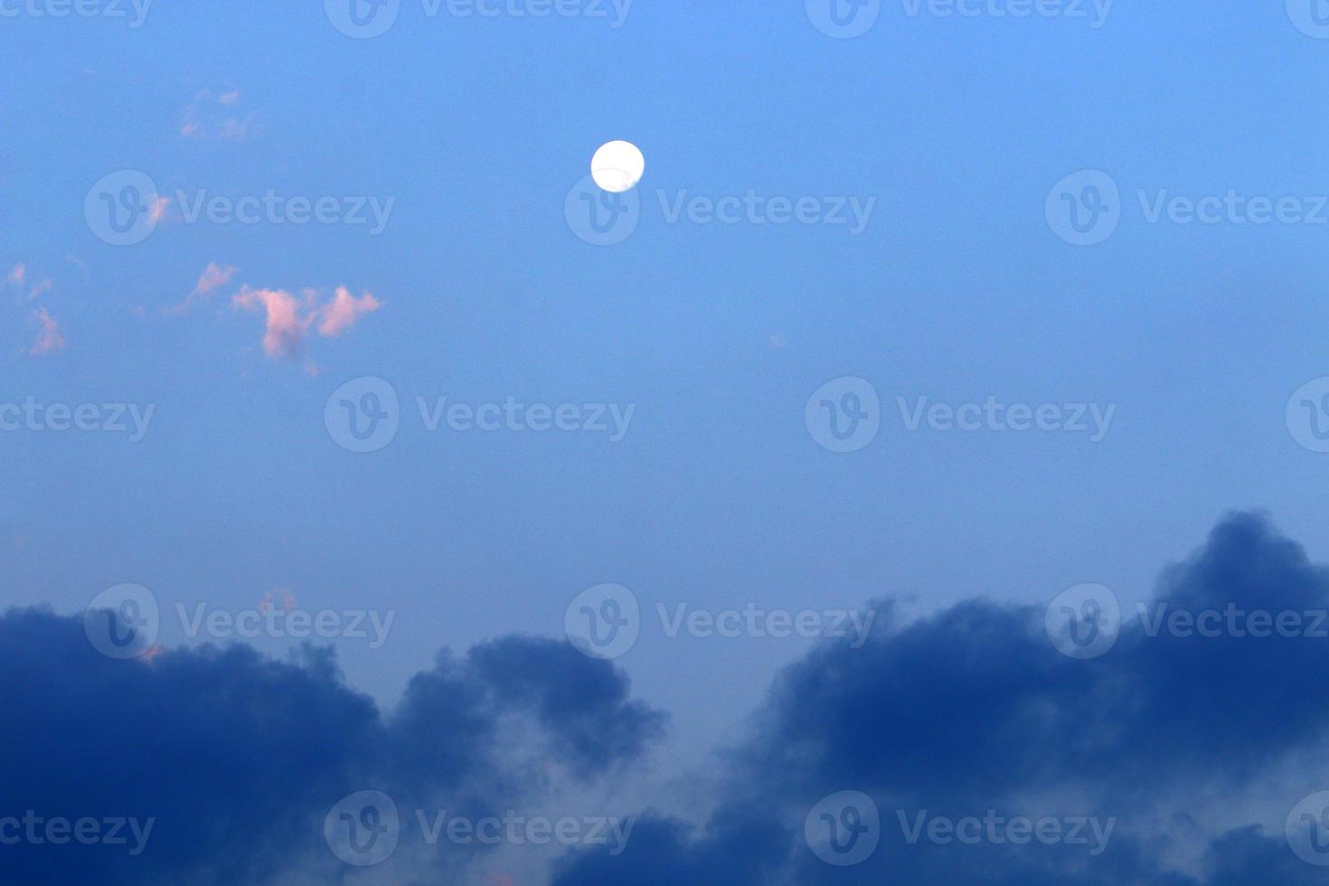 Moon and clouds in the sky over the sea photo