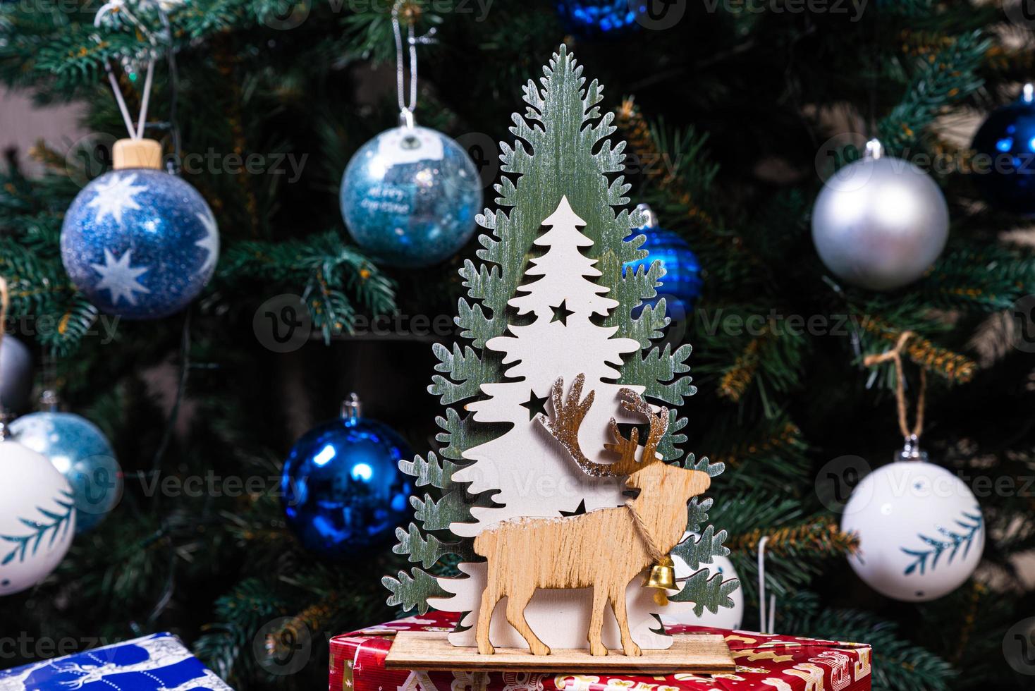 alce tejido de madera. lindo alce juguete contra el fondo de una guirnalda de año nuevo, liebre tejida y alces en un árbol de navidad foto