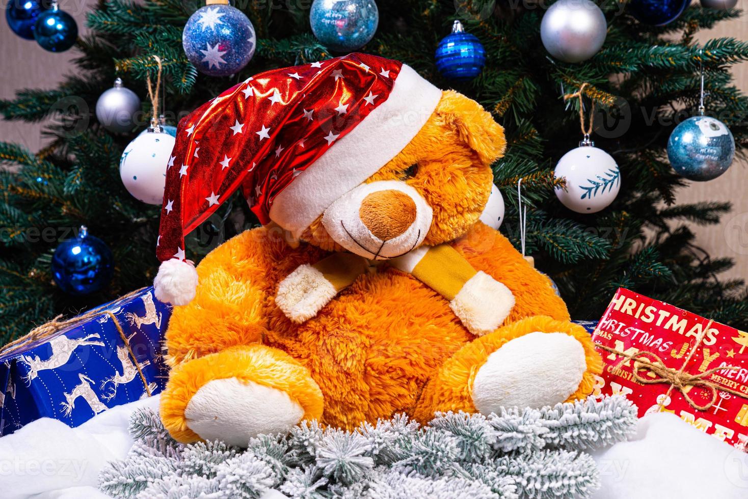 Toy bear wishes you a Merry Christmas. New Year. Christmas decorations, toys, gifts. Souvenirs for the new year. Christmas decoration. Garland. Christmas symbol. Santa Claus, photo