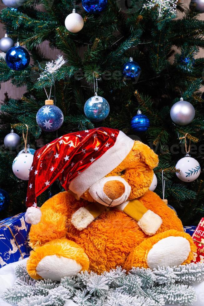 Toy bear wishes you a Merry Christmas. New Year. Christmas decorations, toys, gifts. Souvenirs for the new year. Christmas decoration. Garland. Christmas symbol. Santa Claus, photo