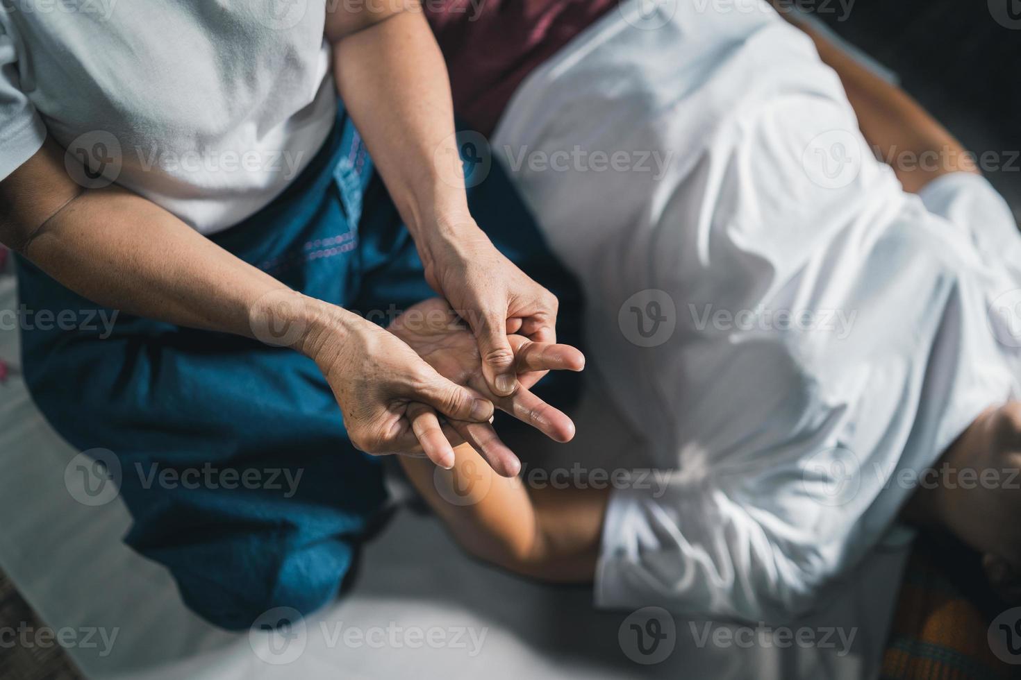 Massage and spa relaxing treatment of office syndrome traditional thai massage style. Asain senior female masseuse doing massage treat hand, back pain, arm pain, foot and stress for old woman tired. photo