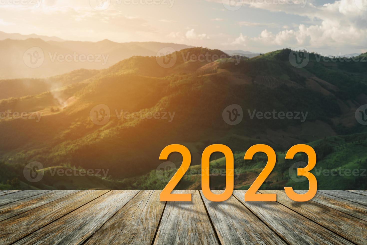 Happy new year 2023,2023 symbolizes the start of the new year. The letter start new year 2023 on the wooden table terrace sunset landscape mountain environment ecology or greenery wallpaper concept. photo