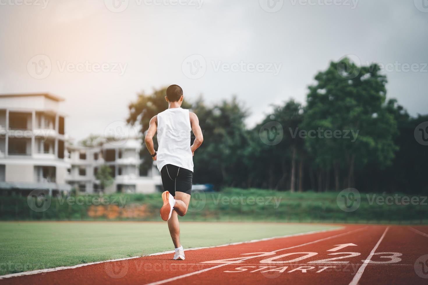 Happy new year 2023 Sport man runner running into the new year 2023. Start up of runner man jogging at stadium go to Goal of Success. People running as part of Number 2023. Sport health care. photo