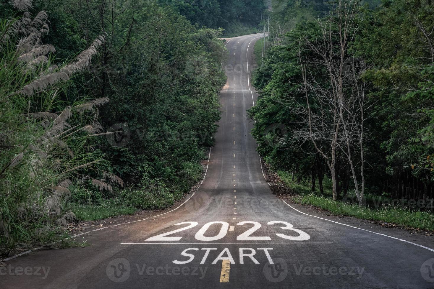 feliz año nuevo 2023,2023 simboliza el comienzo del nuevo año. la carta comienza el nuevo año 2023 en la carretera en la ruta de la naturaleza, la carretera tiene un concepto de ecología del entorno arbóreo o papel tapiz verde. foto