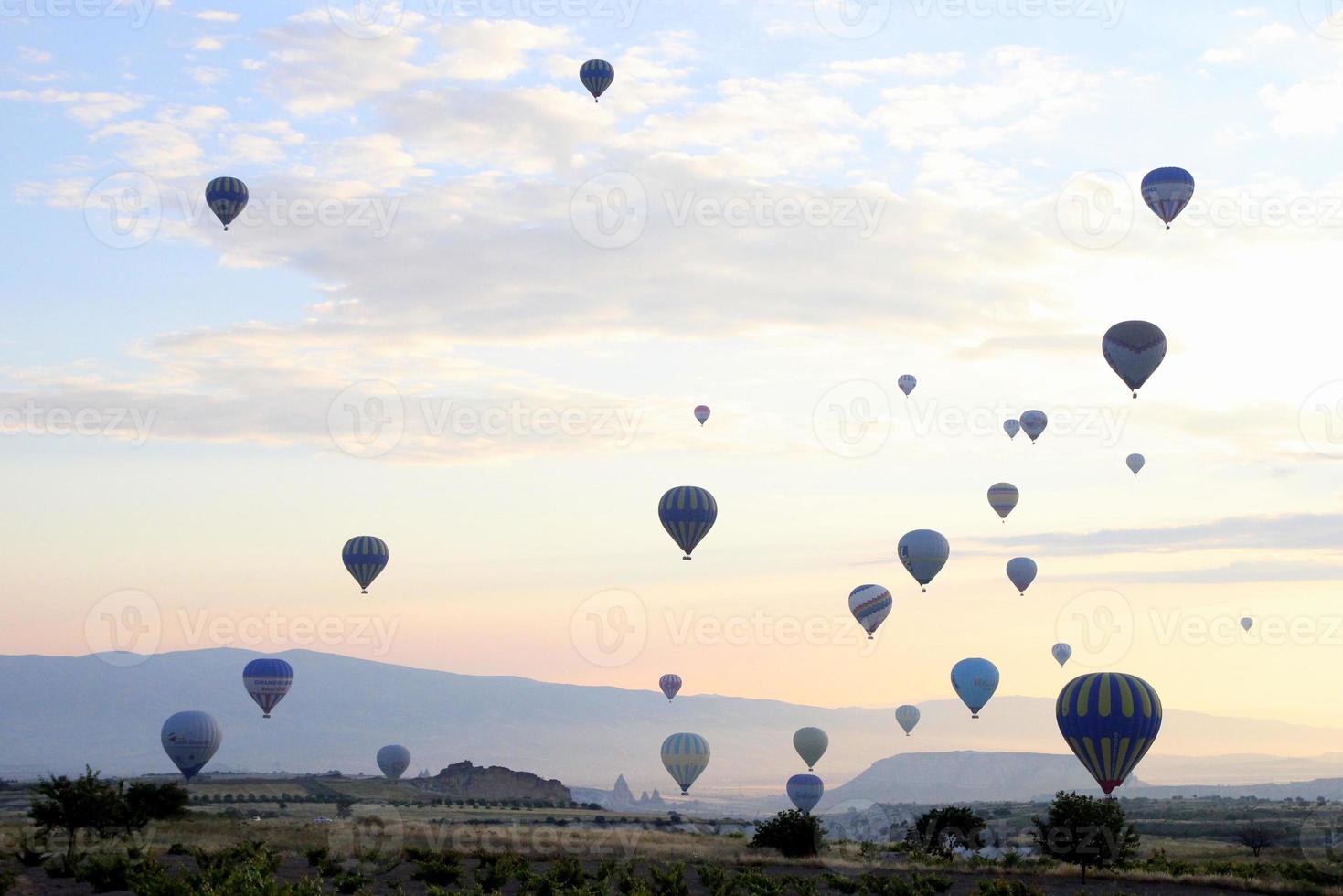 Travel to Goreme, Cappadocia, Turkey. The sunrise in the mountains with a lot of air hot balloons in the sky. photo