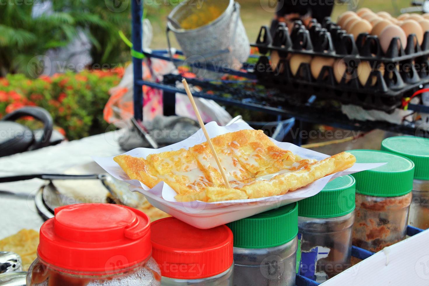 panqueque de plátano tailandés con leche condensada en un plato blanco. comida callejera tailandesa. Ayutthaya, Tailandia. foto