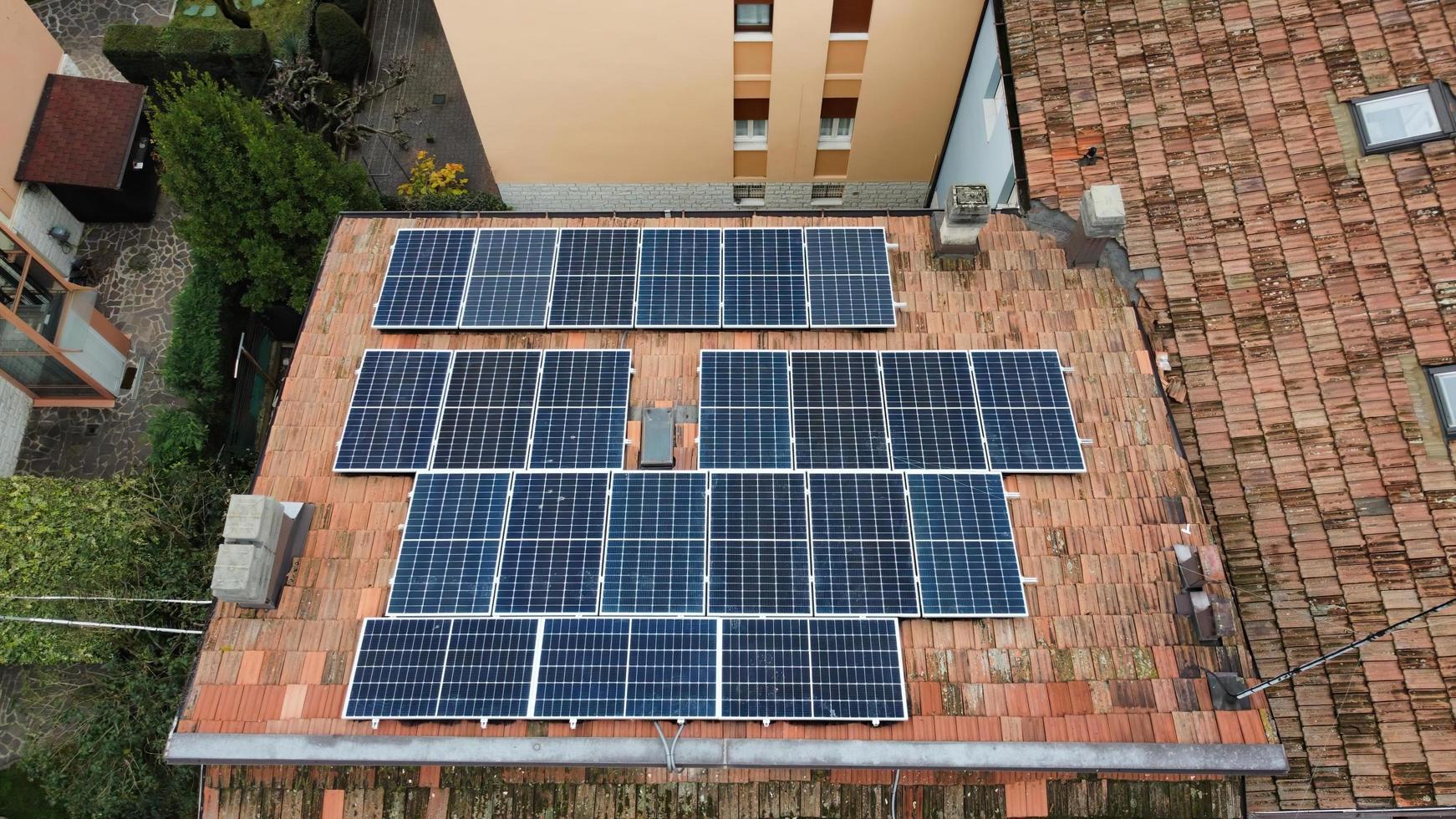 vista aérea de arriba hacia abajo de los módulos de paneles solares montados en el techo. estación de energía solar desde la vista de drones. concepto de energía alternativa. Bolonia, Italia. foto