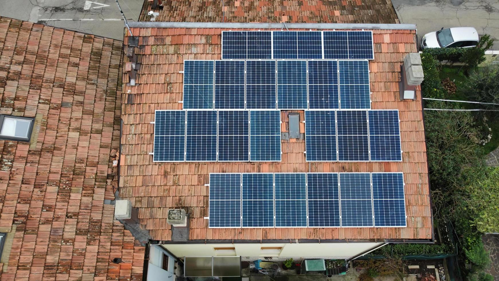 vista aérea de arriba hacia abajo de los módulos de paneles solares montados en el techo. estación de energía solar desde la vista de drones. concepto de energía alternativa. Bolonia, Italia. foto