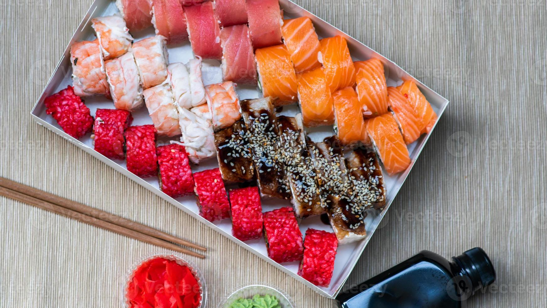 Tasty sushi and sushi roll set with wasabi and ginger on grey background.. Seafood. photo