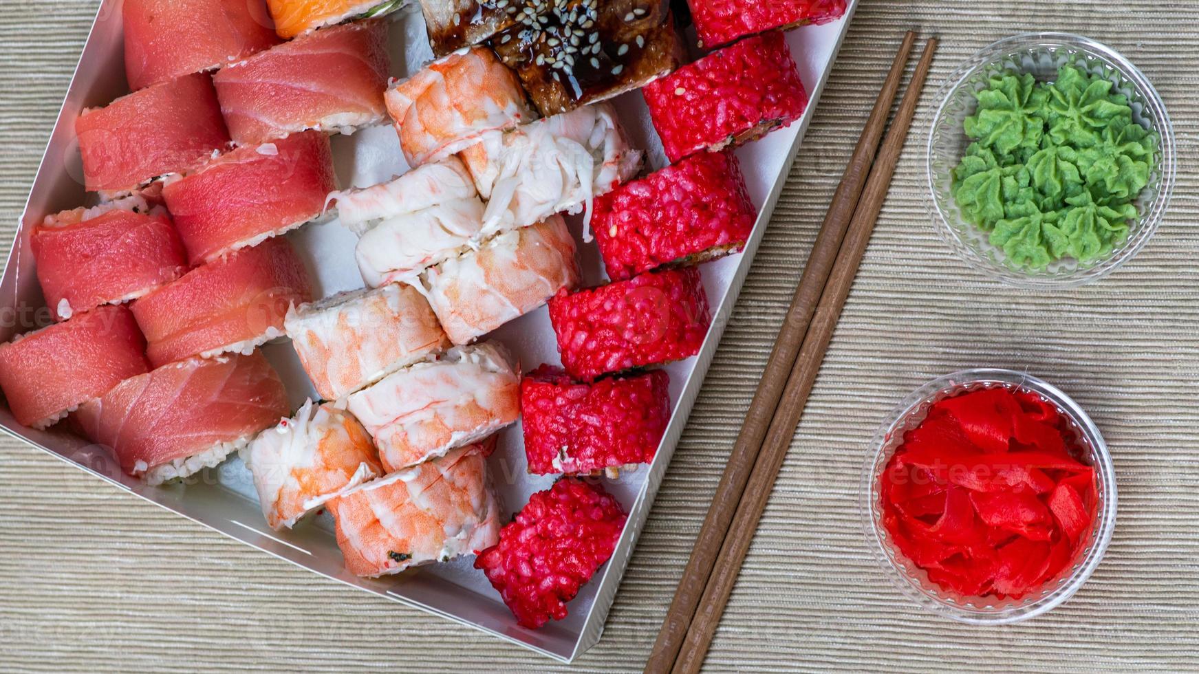 Tasty sushi and sushi roll set with wasabi and ginger on grey background.. Seafood. photo