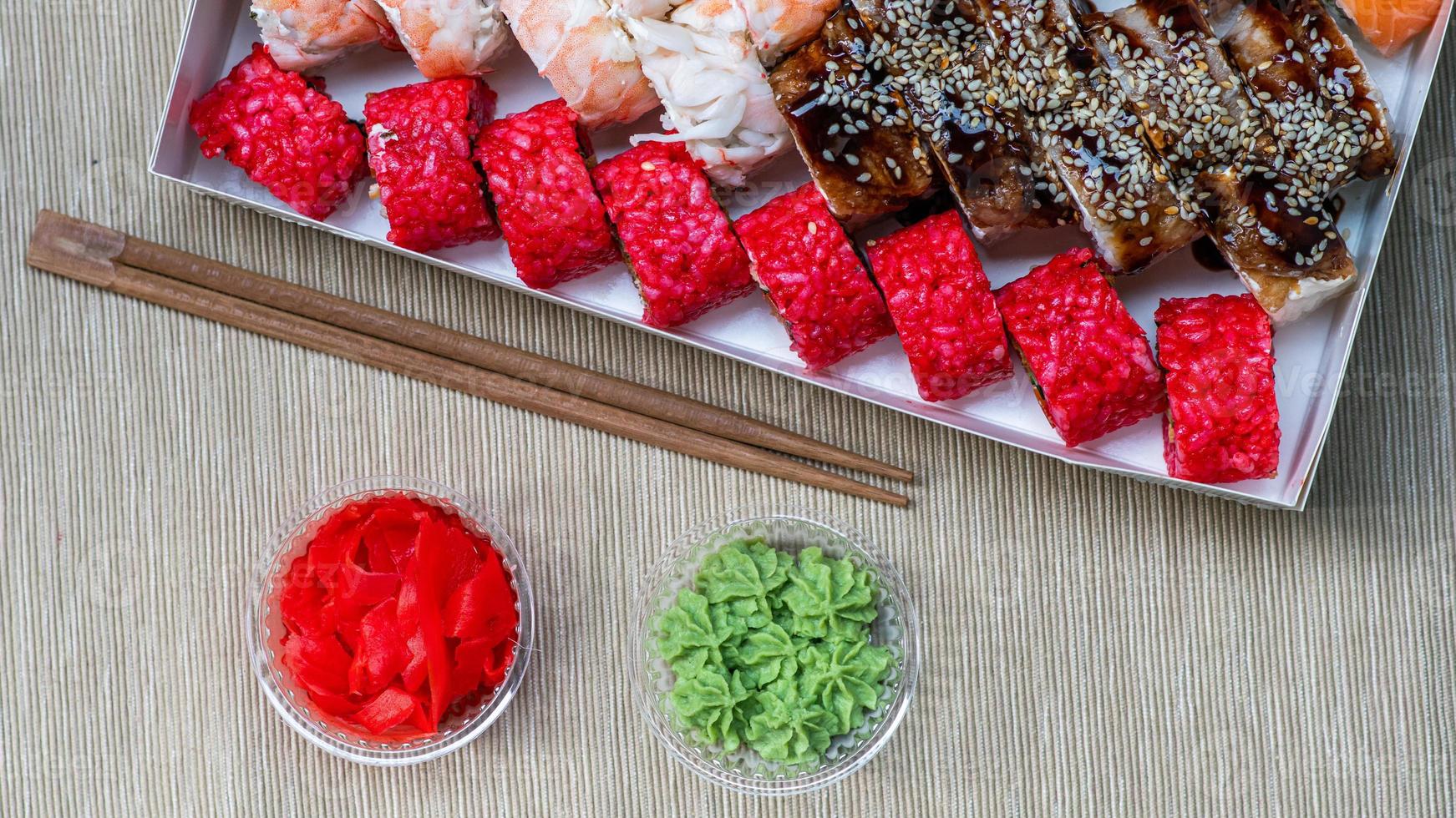 Tasty sushi and sushi roll set with wasabi and ginger on grey background.. Seafood. photo