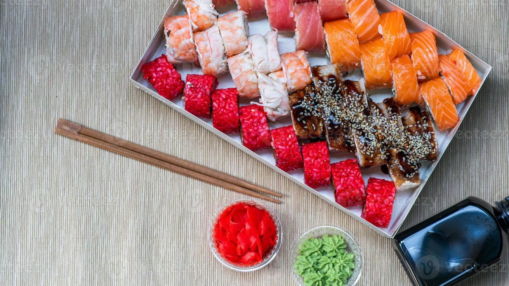 Tasty sushi and sushi roll set with wasabi and ginger on grey background.. Seafood. photo