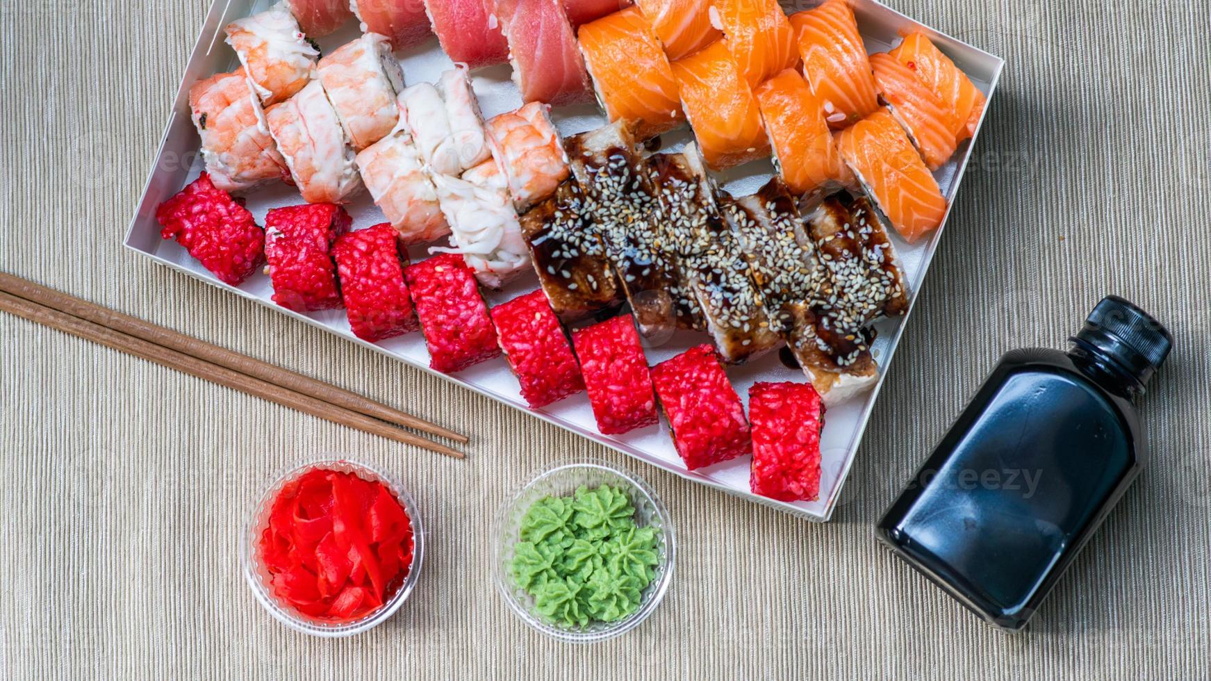 Tasty sushi and sushi roll set with wasabi and ginger on grey background.. Seafood. photo