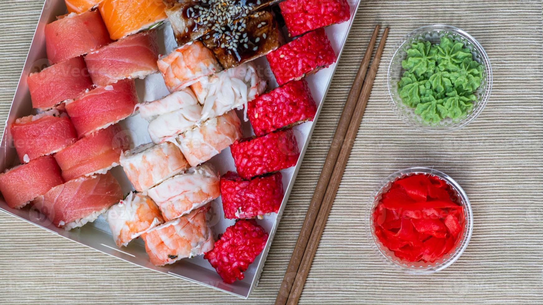 Tasty sushi and sushi roll set with wasabi and ginger on grey background.. Seafood. photo