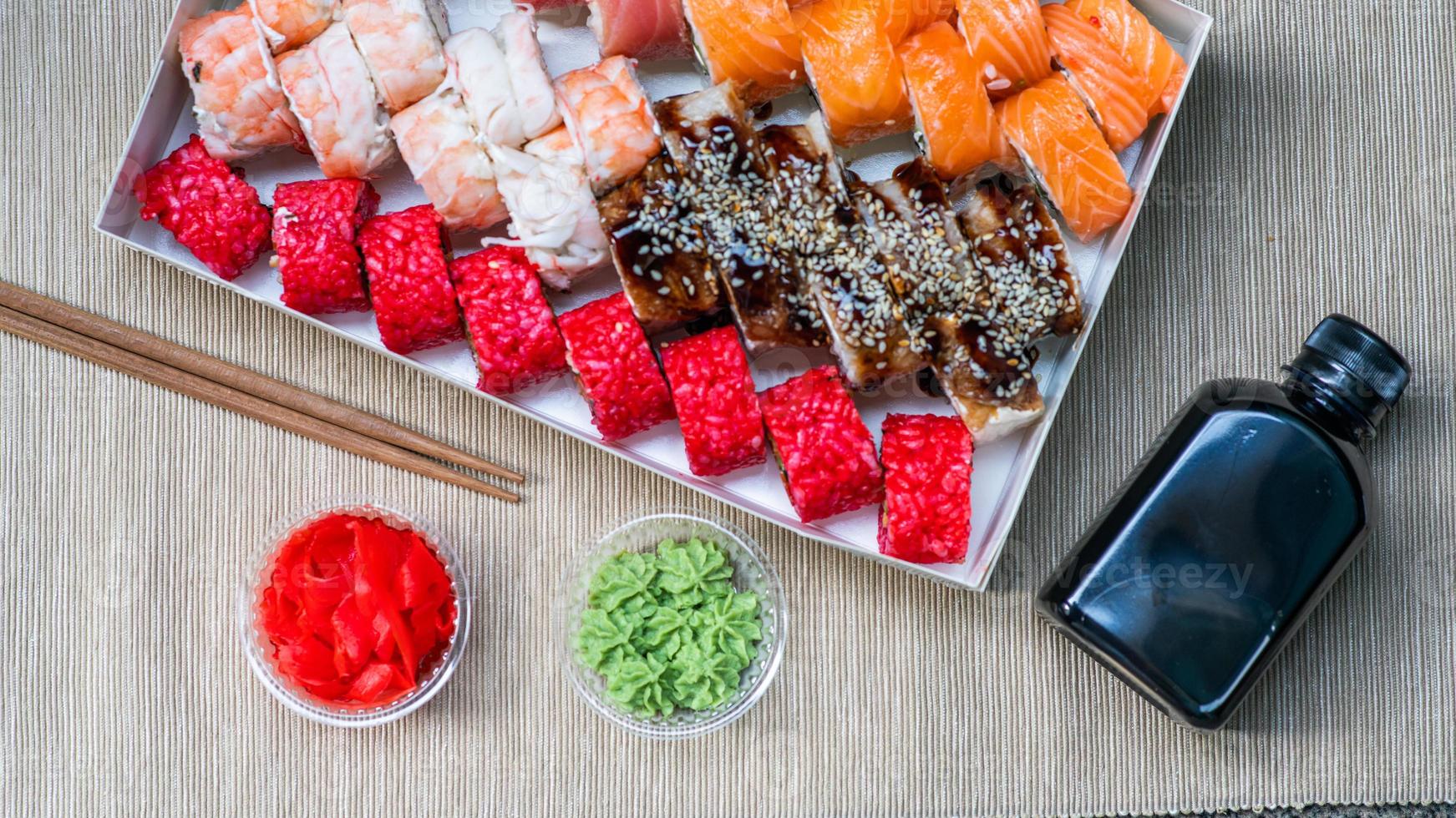 Tasty sushi and sushi roll set with wasabi and ginger on grey background.. Seafood. photo