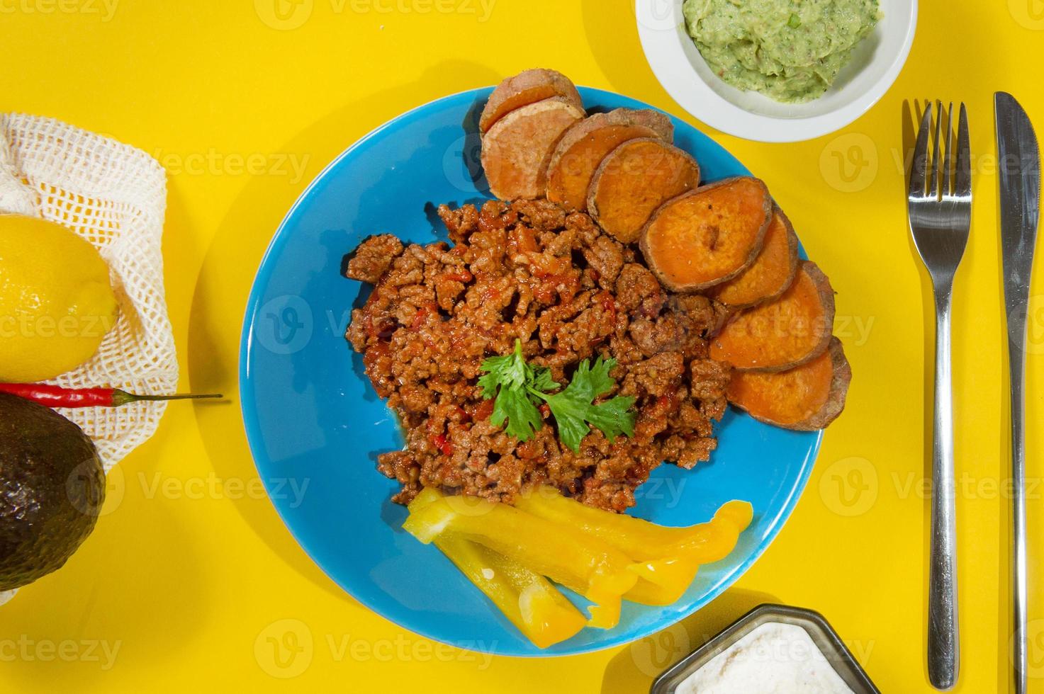 estofado de frijoles con carne molida, batatas y vegetales servidos en una sartén rústica de hierro fundido sobre una mesa de madera. comida saludable y sin gluten foto