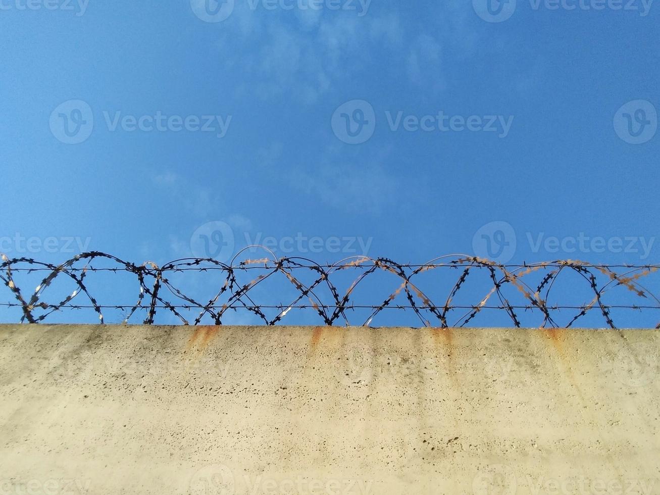 Barbed wire prison wall with blue sky background. 16662901 Stock Photo