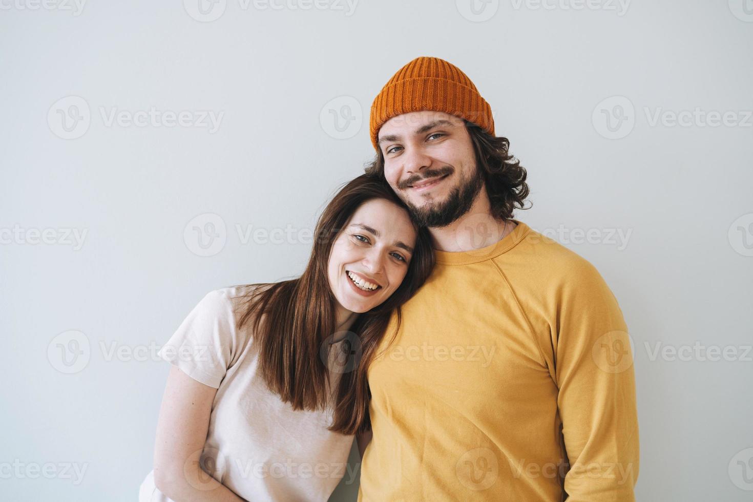 Portrait of happy couple young family laughing against the gray wall photo