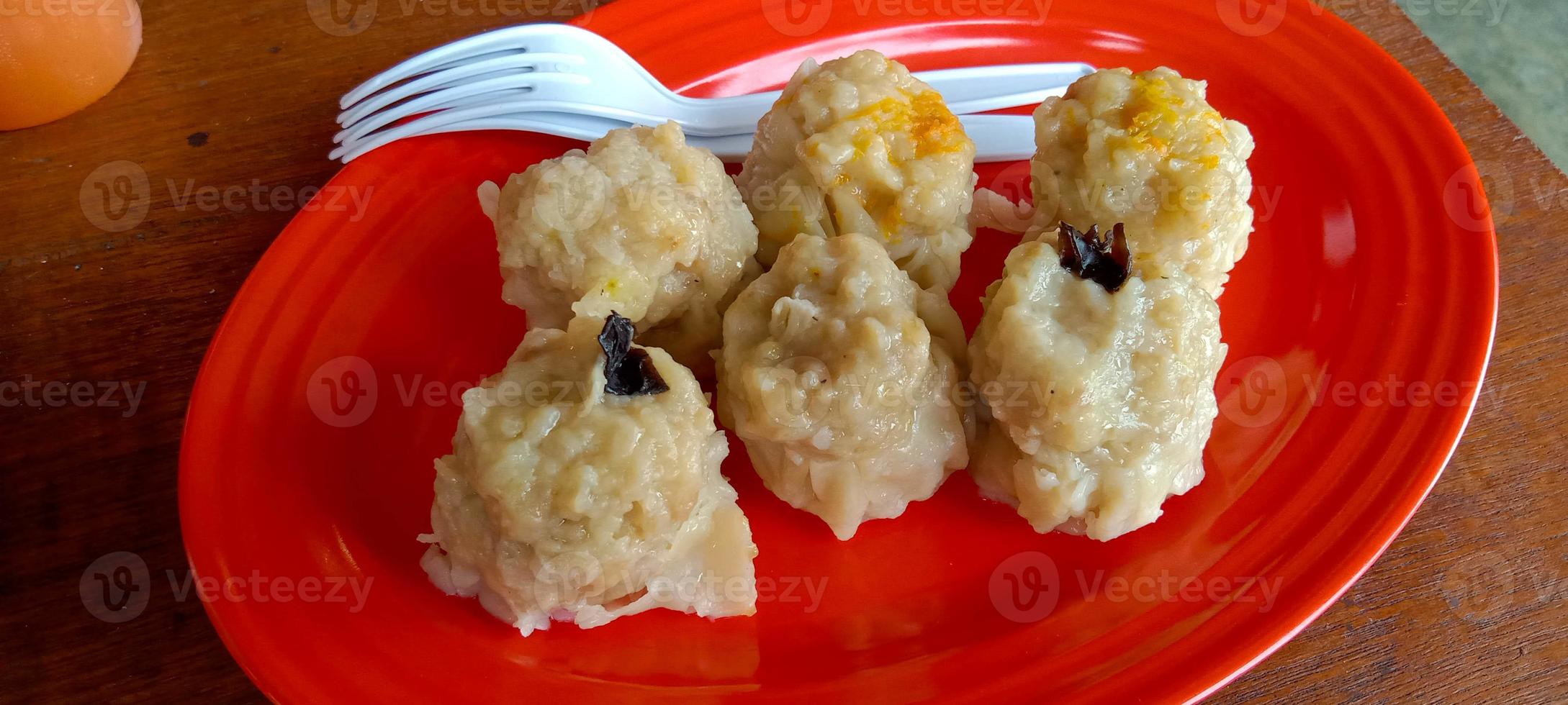 dimsum de bola de masa hervida al vapor servido en un plato. comida china en la mesa foto