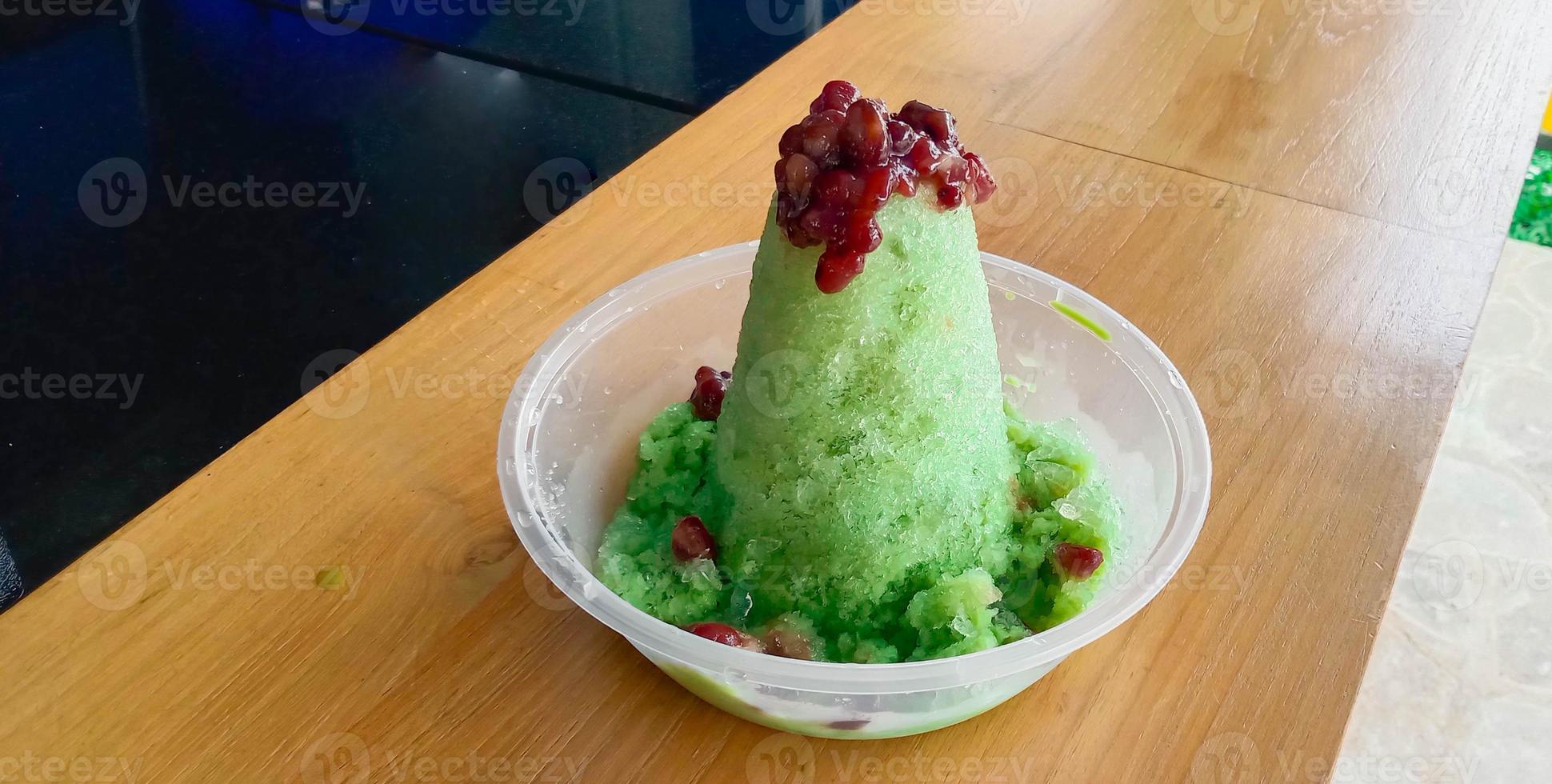 kakigori es un postre de hielo raspado japonés, con frijoles rojos y salsa dulce sobre helado. postre tradicional de verano en japón foto