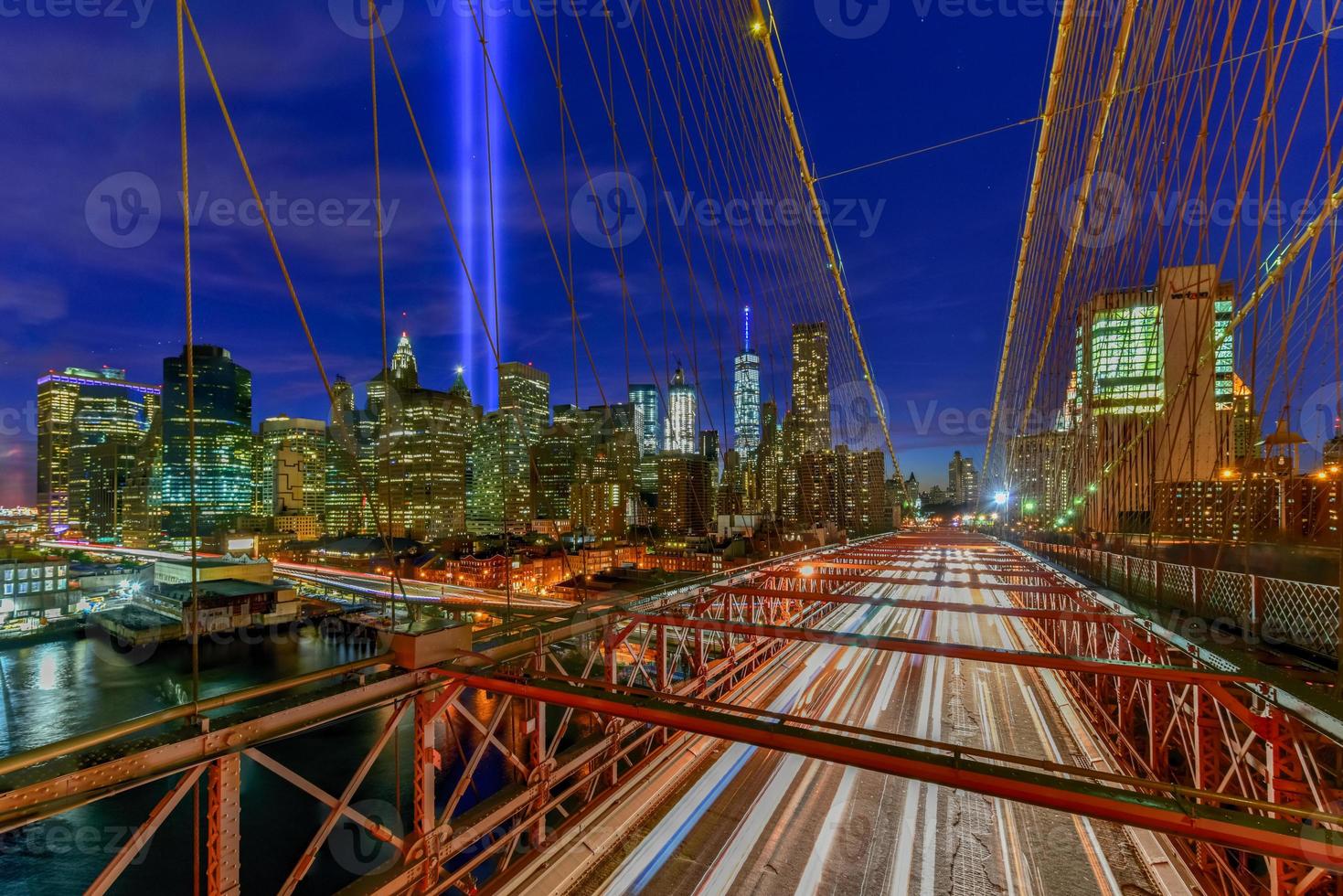 New York City Manhattan downtown skyline at night from the Brooklyn Bridge with the Tribute in Light in memory of September 11. photo