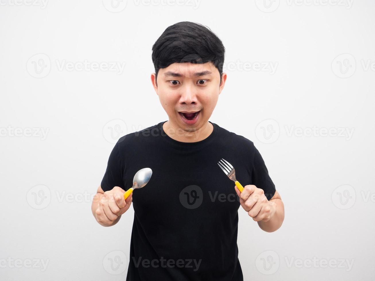 hombre sosteniendo una cuchara sintiendo hambre y mirando comida foto