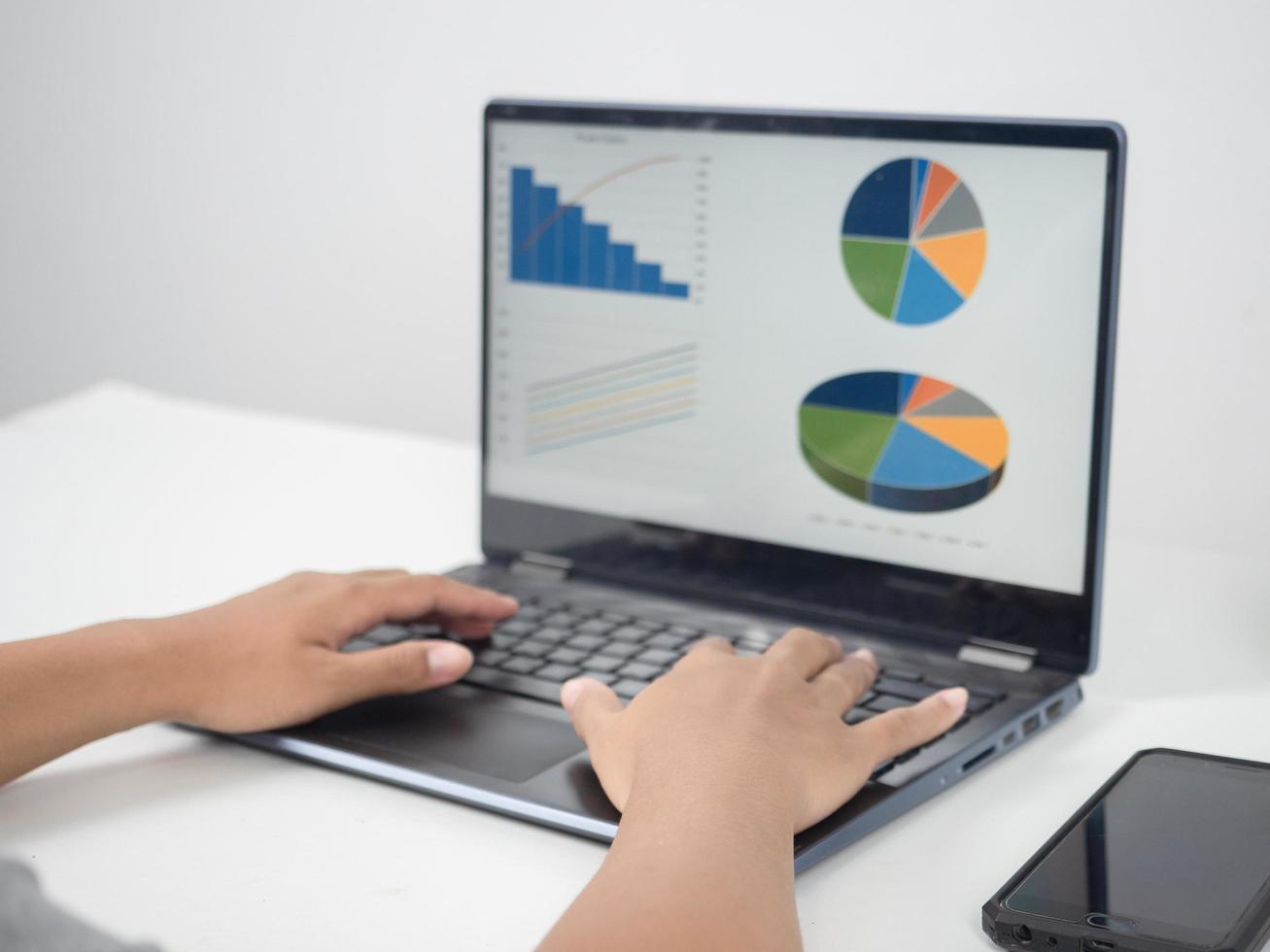 Close up hand using laptop charts graphs business at screen on the table photo