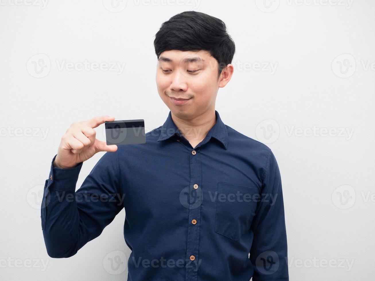 hombre confiado mirando la tarjeta de crédito en su retrato de mano foto