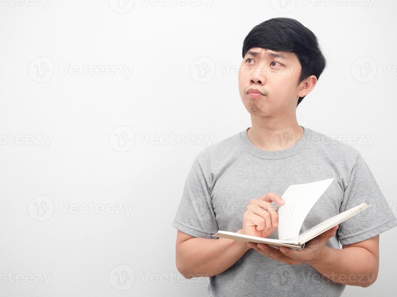hombre sosteniendo un diario con una emoción seria y mirando el espacio de la copia foto