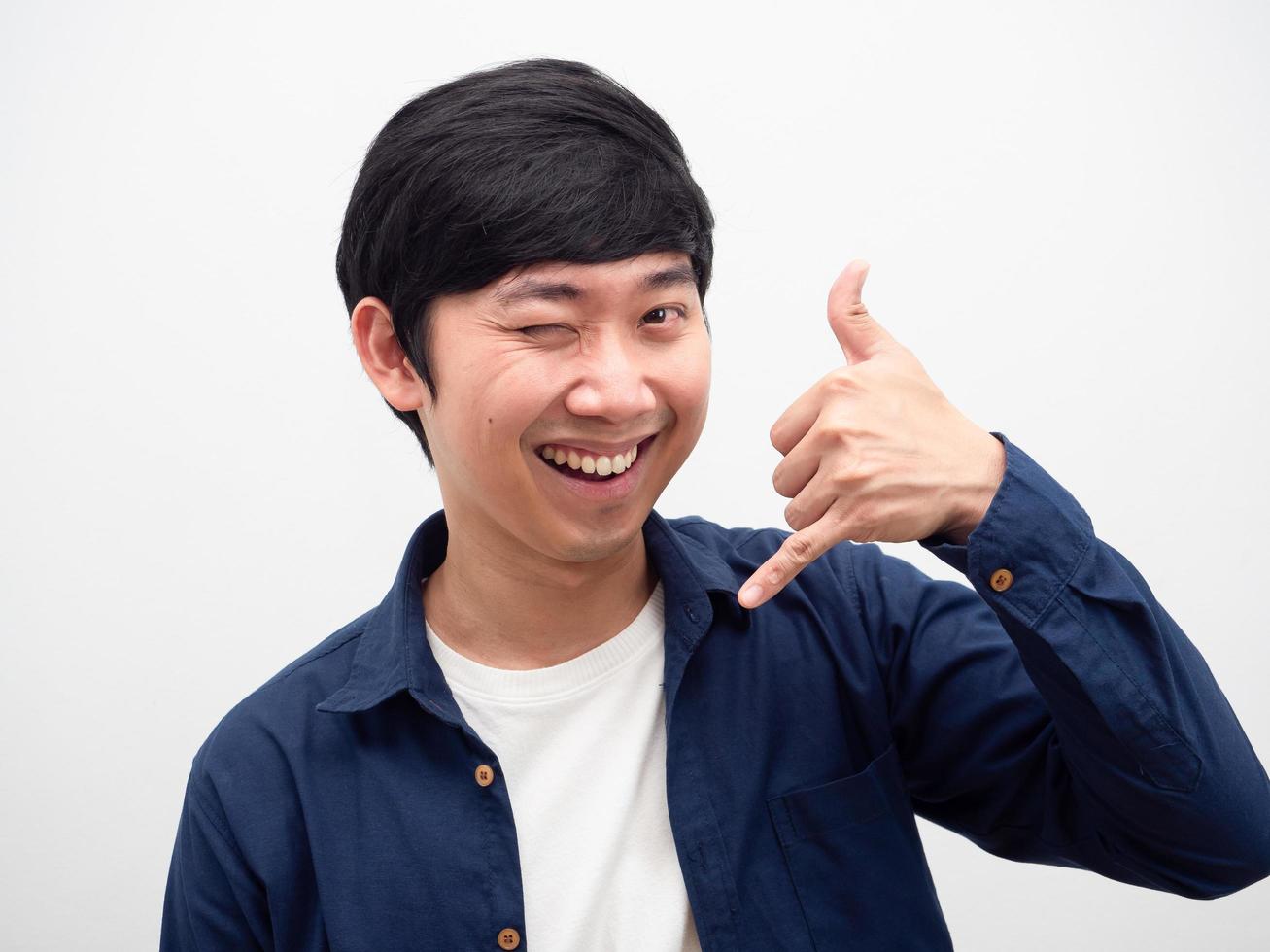 Cheerful man happy smile face gesture hand call mobile and close one eye portrait photo