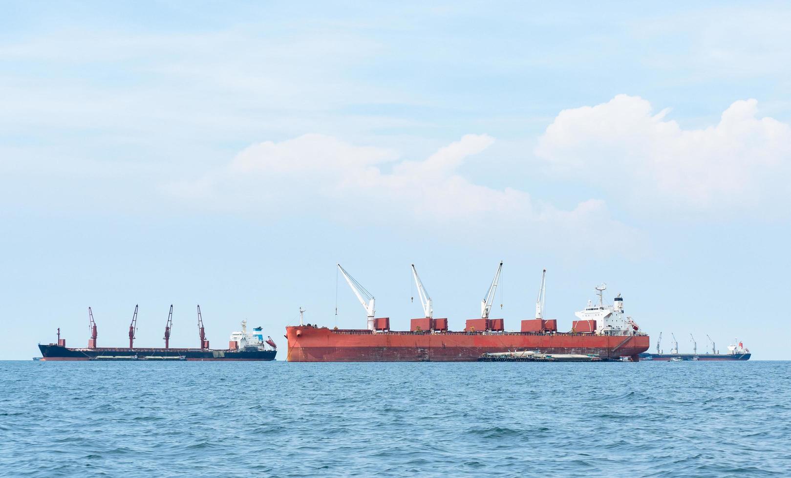 Large ship red color with big crane in the blue ocean and blue sky landscape,Industrial boat in the sea logistic concept photo