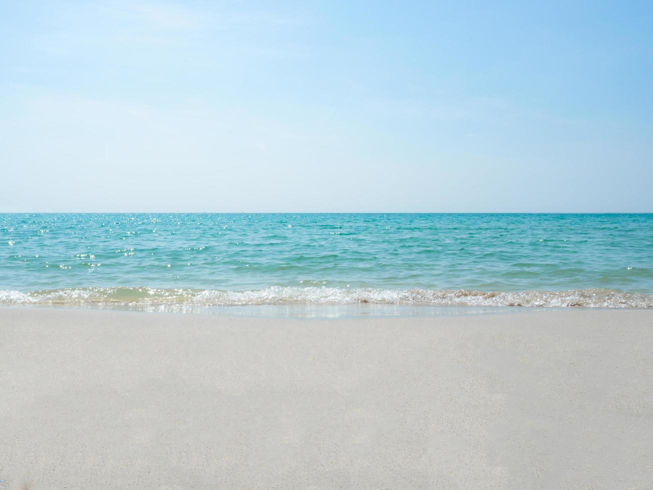 Sand and sea water wave on the beach at blue ocean blue sky landscape,Sea water wave bubble concept beautiful ocean with sunlight photo