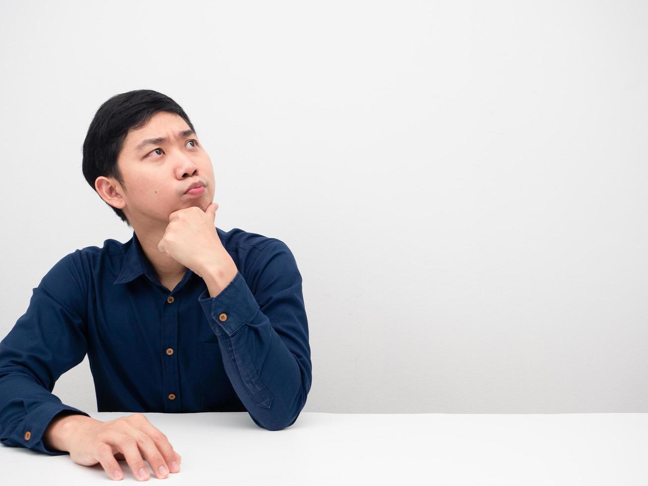 Man sitting at the table looking at copy space and feeling doubt photo